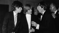 Keith Richards (left) and Brian Jones, chat with Beatle Paul McCartney, in the early hours (7th July) at the Dorchester Hotel London, to celebrate the premiere (6th July) of The Beatles first film, A Hard Day's Night, The Stones were celebrating too, their disc, It's All Over Now, is top of the charts, pictured 2am Tuesday 7th July 1964.