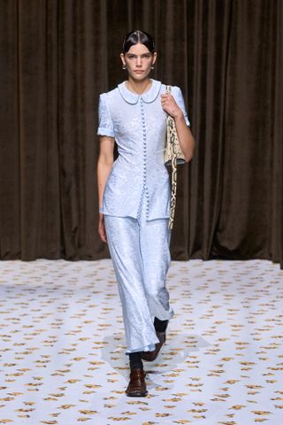 Uma Modelo Usa Um Acessório Com Estampa De Cobra Na Passarela Da Jil Sander.