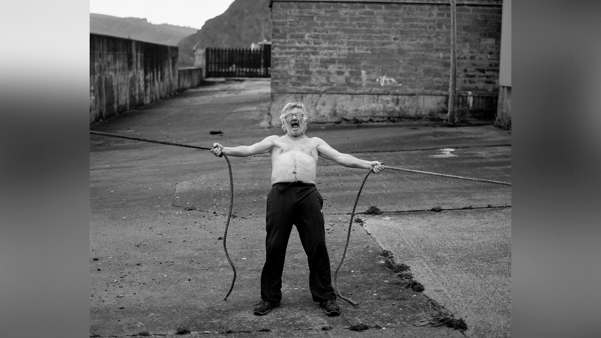 Man holding ropes aggressively.