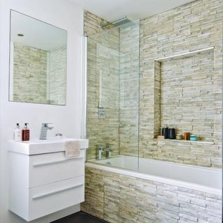 bathroom with bathtub and mirror on white wall