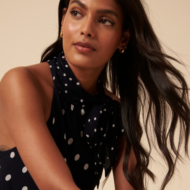 Model wearing a black and white polkadot Nobody's Child dress