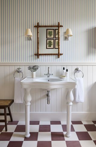 cottage bathroom with wall lights, panelled walls and checkerboard floor