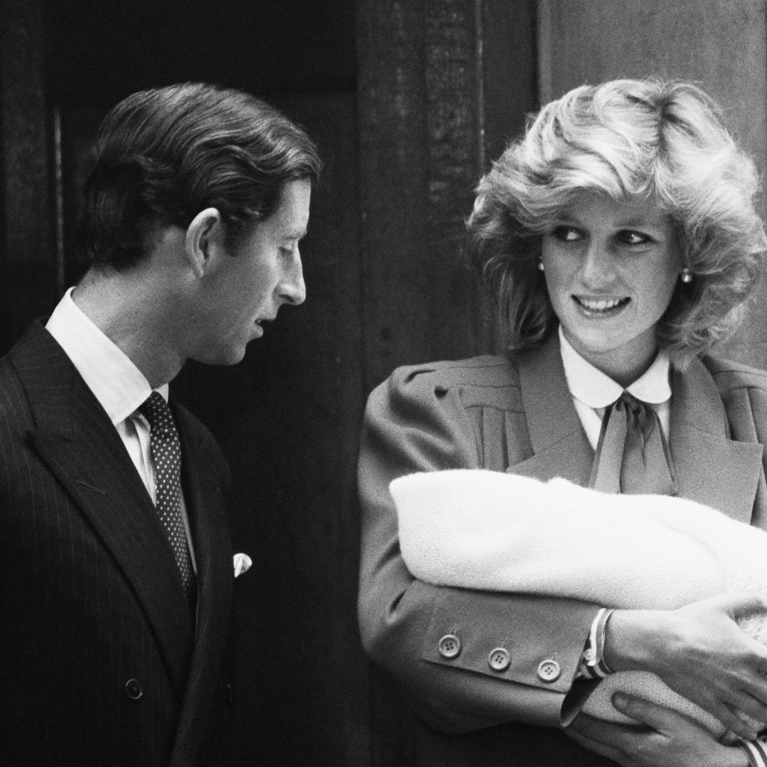 Prince Harry and Princess Diana standing on hospital steps holding Prince Harry as a newborn