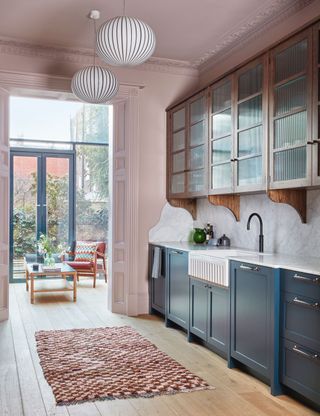 Pink kitchen with blue cabinets and marble