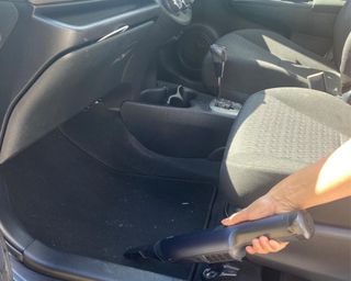 Christina Chrysostomou cleaning interior of Toyota Yaris with Shark Wandavac cordless handheld vacuum cleaner
