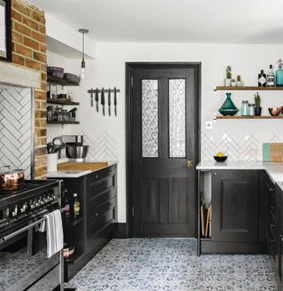 kitchen room with black cabinets and white marble worktop with metro tiles