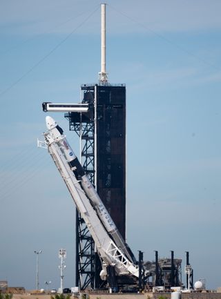 A SpaceX Falcon 9 is raised up on the launch pad ahead of Crew-3.