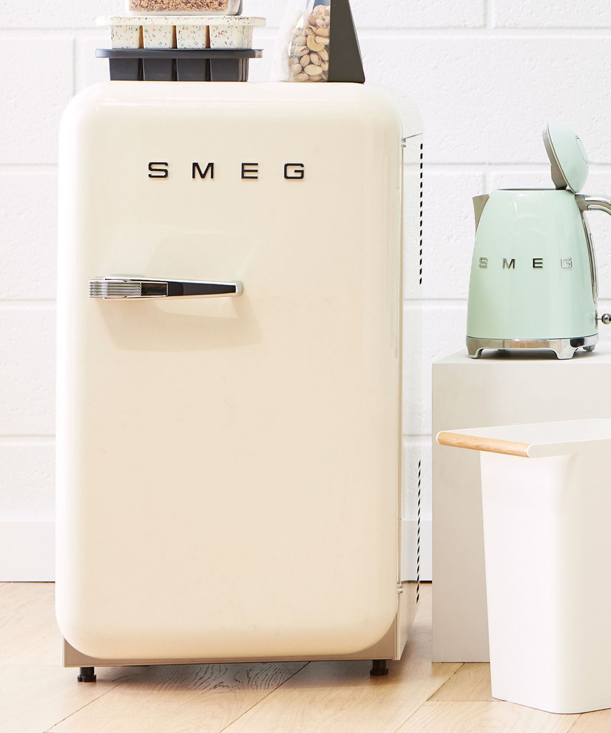 Cream SMEG mini fridge next to mint green SMEG kettle
