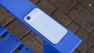 The back of an iPhone Air in Sky Blue on a blue chair.