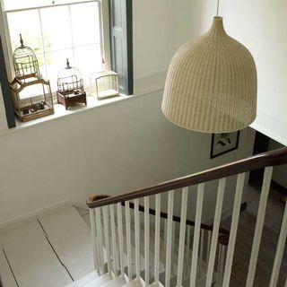 white wooden floorboard with white stairway and window