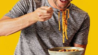 Man eating tagliatelle meal from Muscle Foods' prepped meals