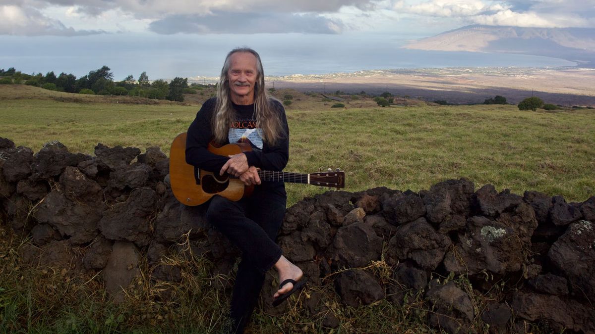 Jeff Cotton sitting on a fence in a field