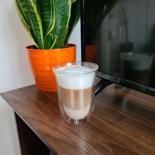Glass of latte macchiatto made in a De'Longhi Dinamica Plus