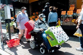 A lady in a motorised chair Navigating the sidewalk after stocking up on paper towels, 82nd Street at Roosevelt Avenue, Queens, NY