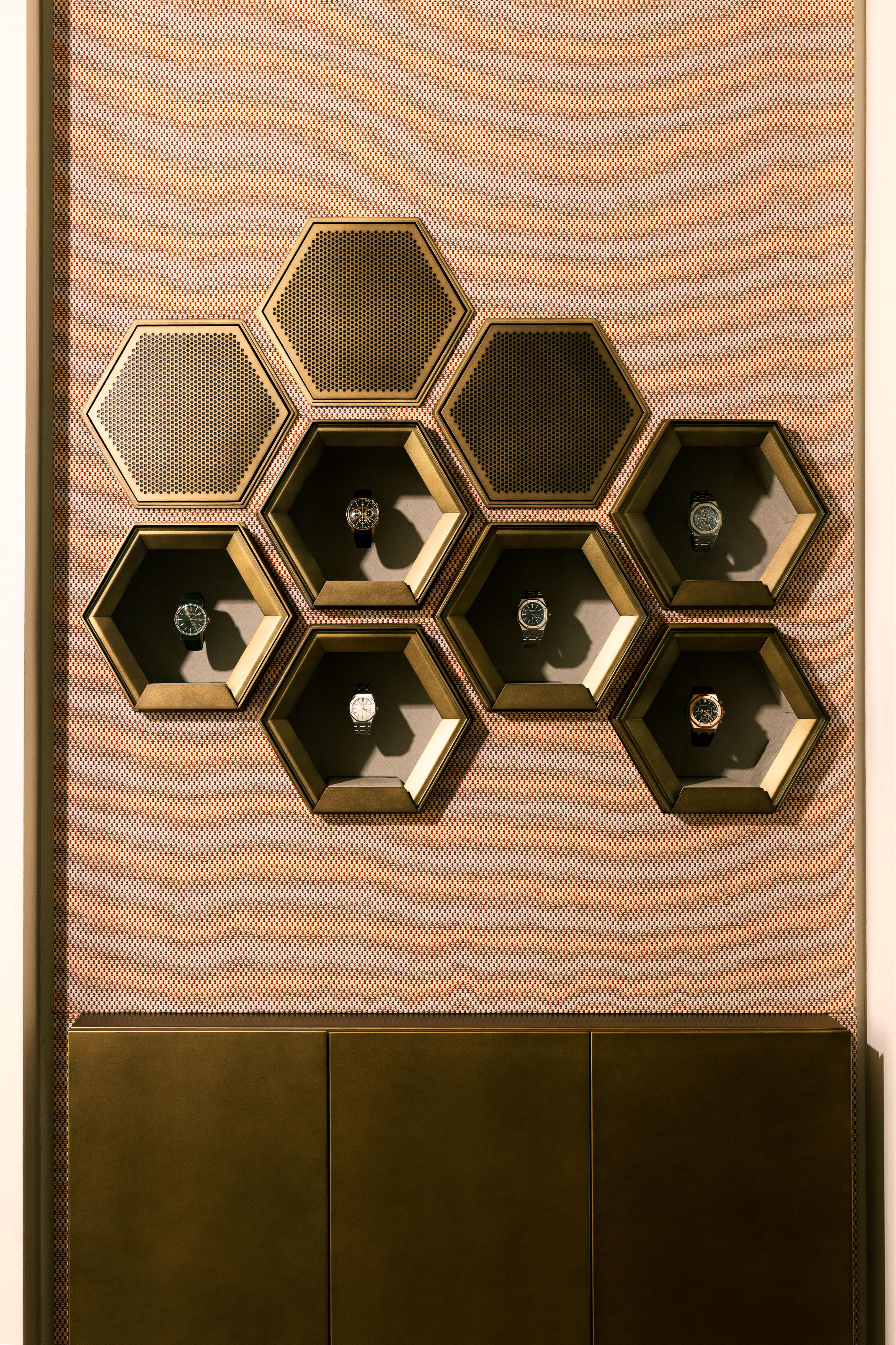 golden honeycomb-pattern watch display on wall
