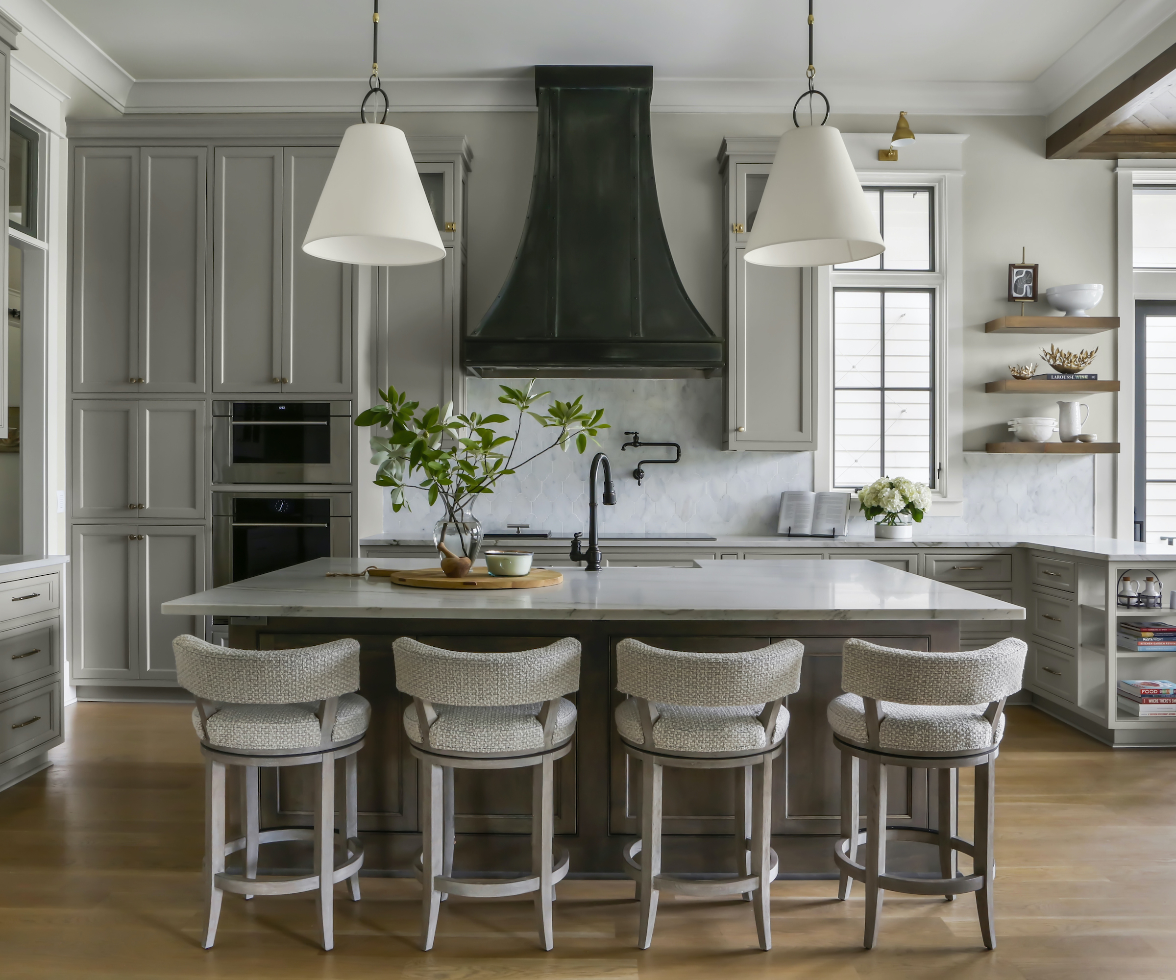 kitchen island with four stools and cooker hood behind