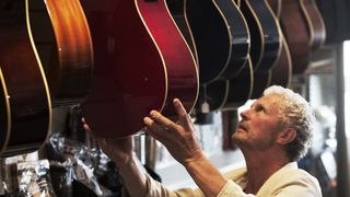 Man looking at guitars in a guitar shop