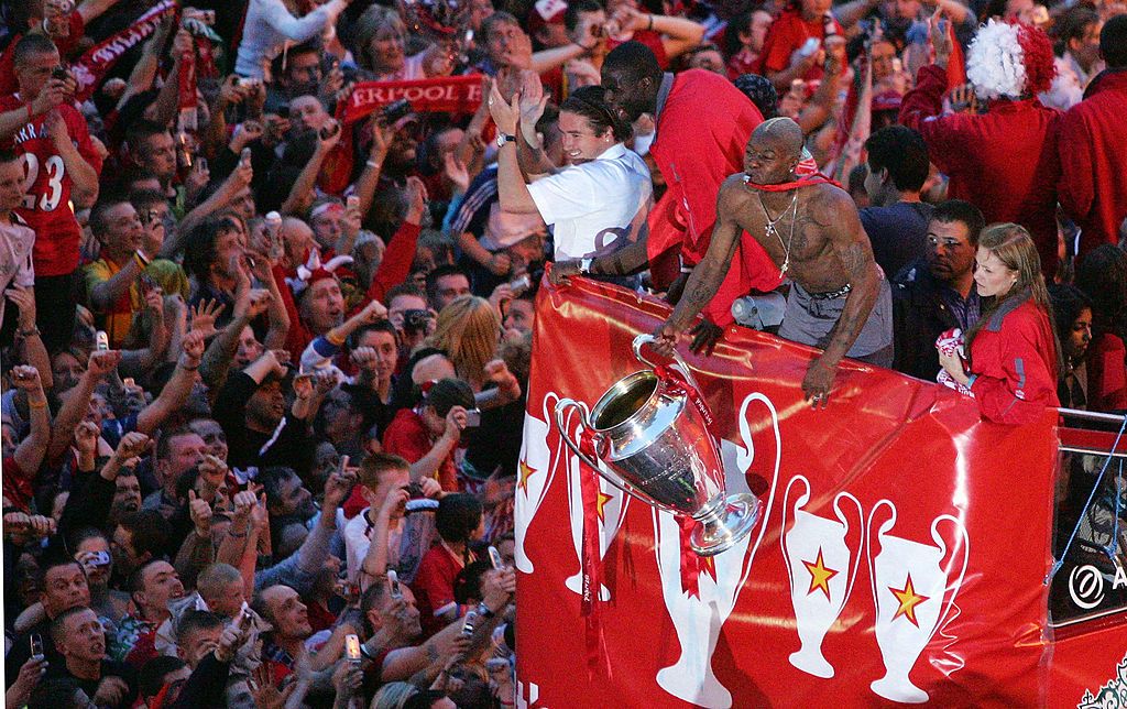 Liverpool&#039;s French striker Djibril Cisse celebrates with the trophy as the Liverpool team rides on an open top bus through a mass of fans as they arrive at St. George&#039;s Hall during the Liverpool Champions League Victory Parade on May 26, 2005 in Liverpool, England. Over 250,000 cheering fans have lined the roads to celebrate after Liverpool defeated AC Milan in a penalty shoot out 3:2 to win the UEFA Champions League Final. 