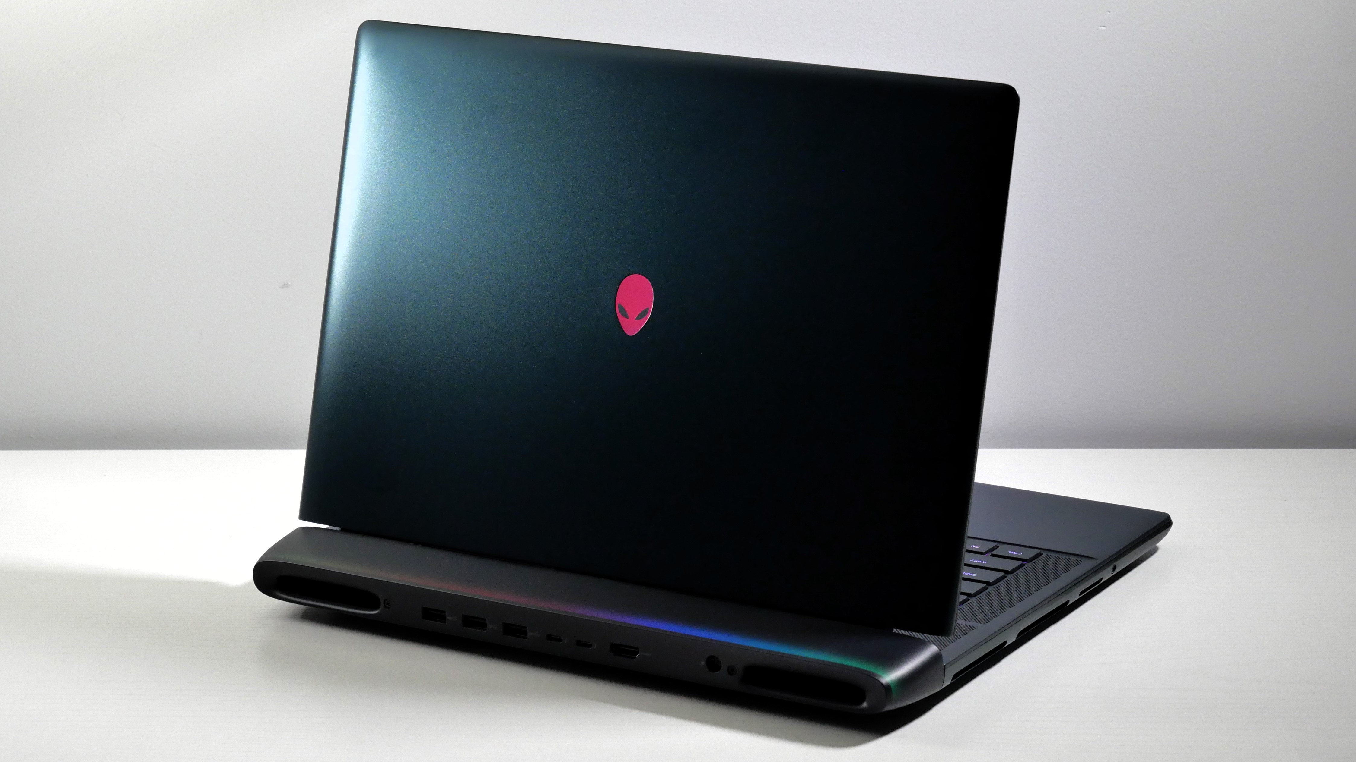 Alienware 16 Area-51 (RTX 5080) open on a white desk, highlighting the dark teal lid.