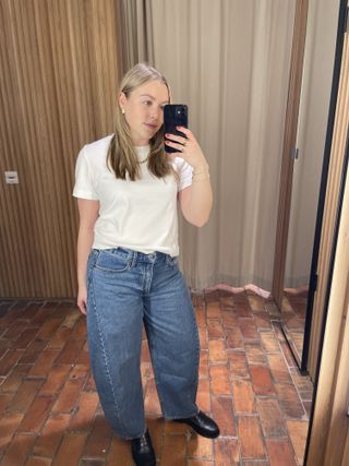 Woman wears white t-shirt and barrel-leg jeans