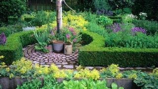 how to design a potager: a water pump used as a focal point in a potager