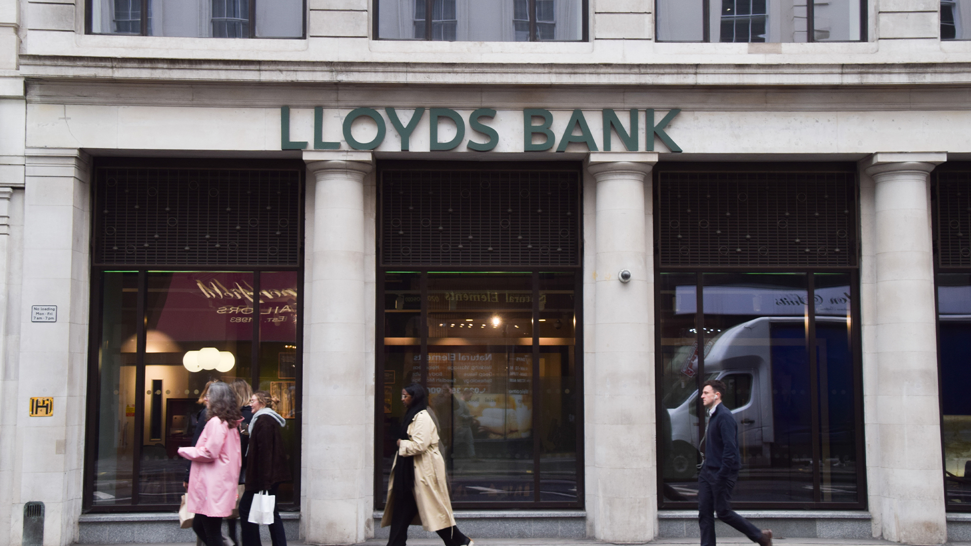 Pedestrians walk past a Lloyds Banking Group branch in Moorgate.