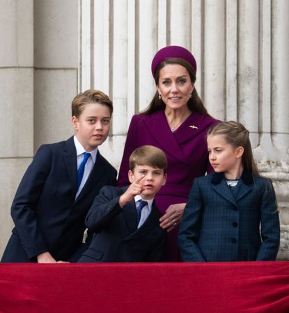 Prince George, Prince Louis, Princess Charlotte and Princess Kate pointing and smiling at a flypast on the Buckingham Palace balcony