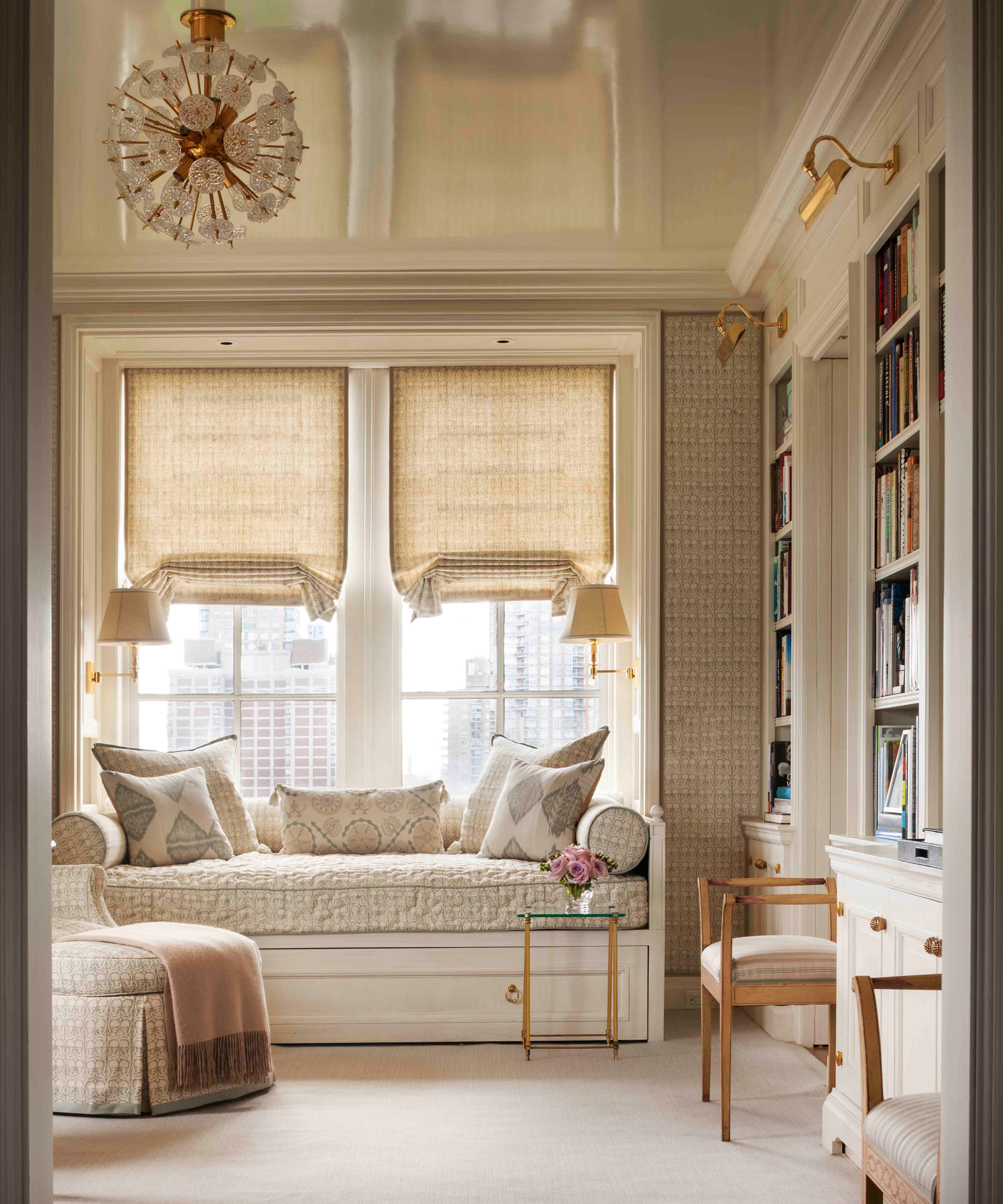 a cozy study with a built in window seat, a wall of built-in shelving, and a ceiling painted with high gloss paint