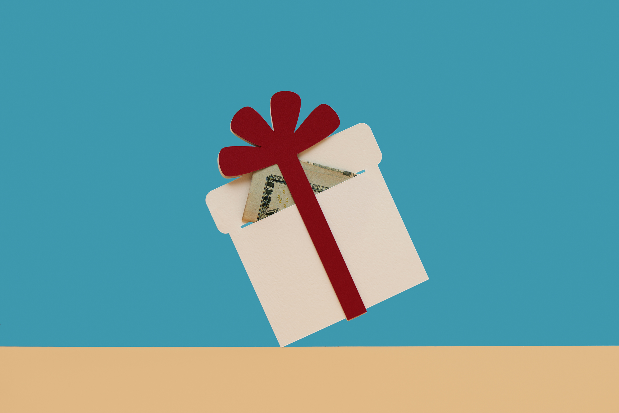 one holiday present with red bow and money inside