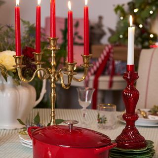 Table with christmas decoration and red candles in brass candlestick holder