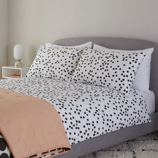 bedroom with bed having dotted pattern bedsheet and pillow covers