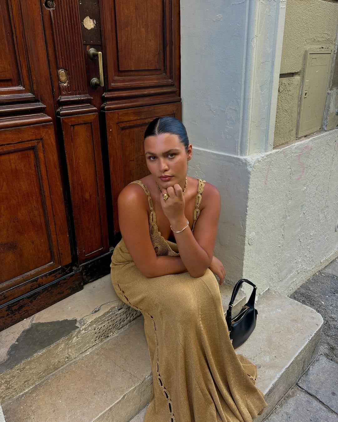 woman wearing gold knit long dress and gold jewelry