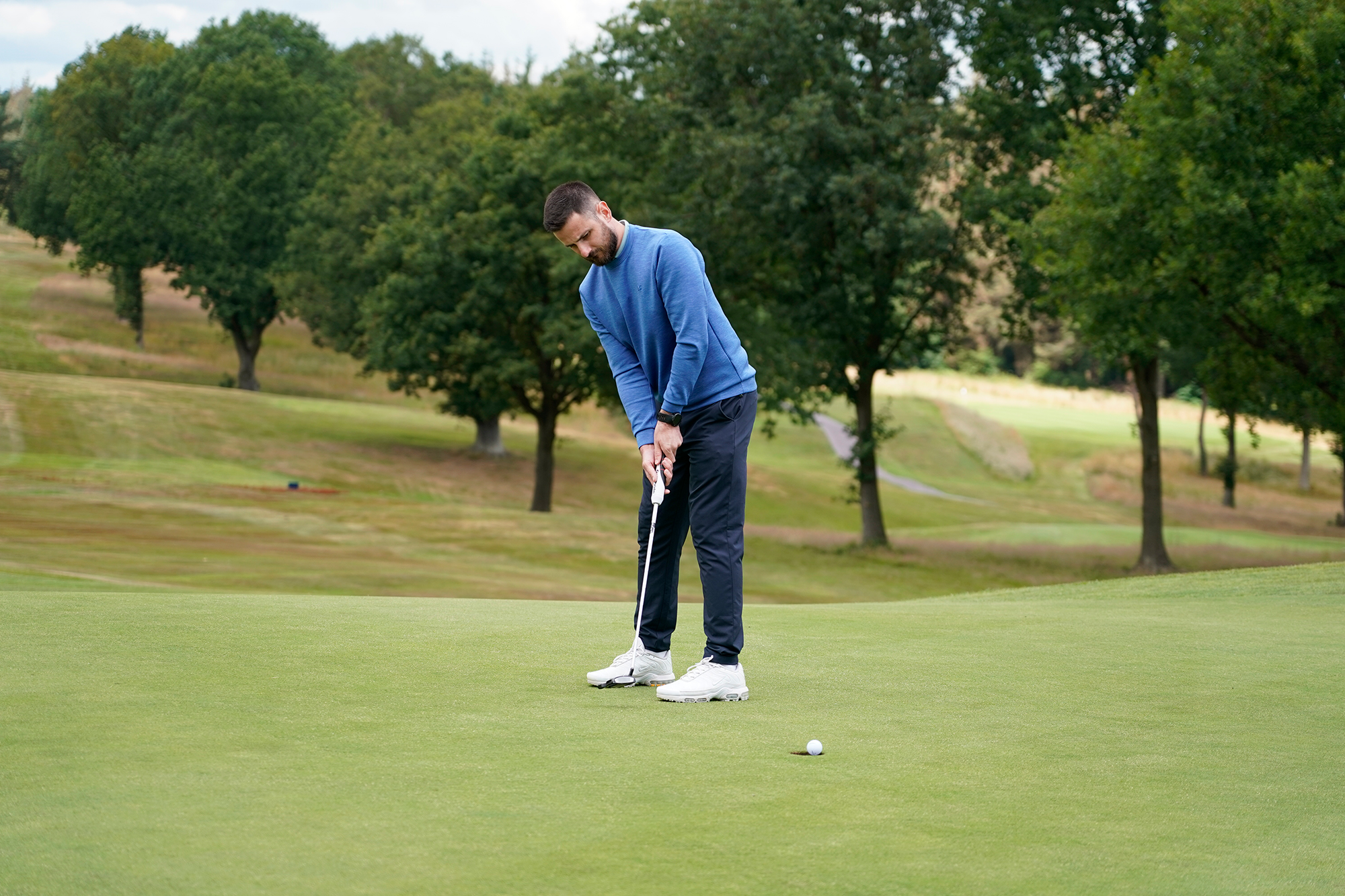 Baz Plummer holing a six foot putt at Sand Moor Golf Club to avoid making a 3-putt