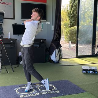 Dan Parker testing the Under Armour Drive Pro SL in a driving range bay