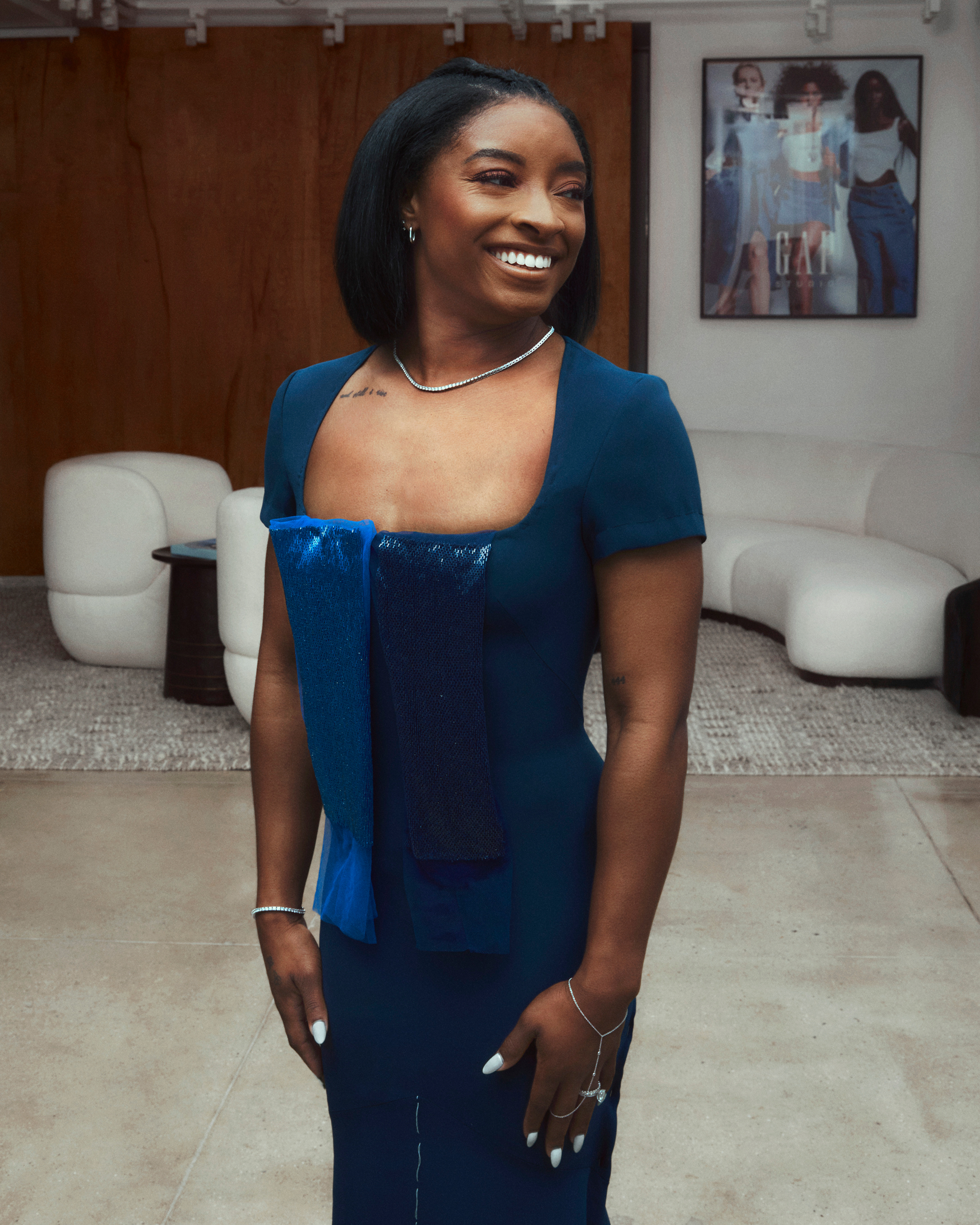 Simone Biles tries on her Athleta red carpet gown with two beaded fabric swatches