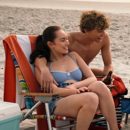 Belly (Lola Tung), Jeremiah (Gavin Casalegno) sitting on the beach on lawn chairs in THE SUMMER I TURNED PRETTY season 3