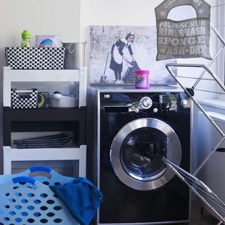 laundry room with washing machine and storage unit