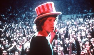 Gimme Shelter Mick Jagger looks back at the camera, with an Uncle Sam hat