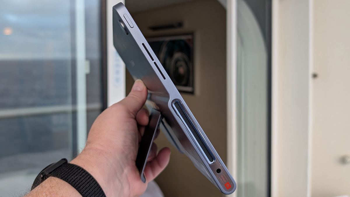 Sideview of Lenovo Tab Plus showing the power button, volume button, side-firing speakers, and the extended kickstand on the back.