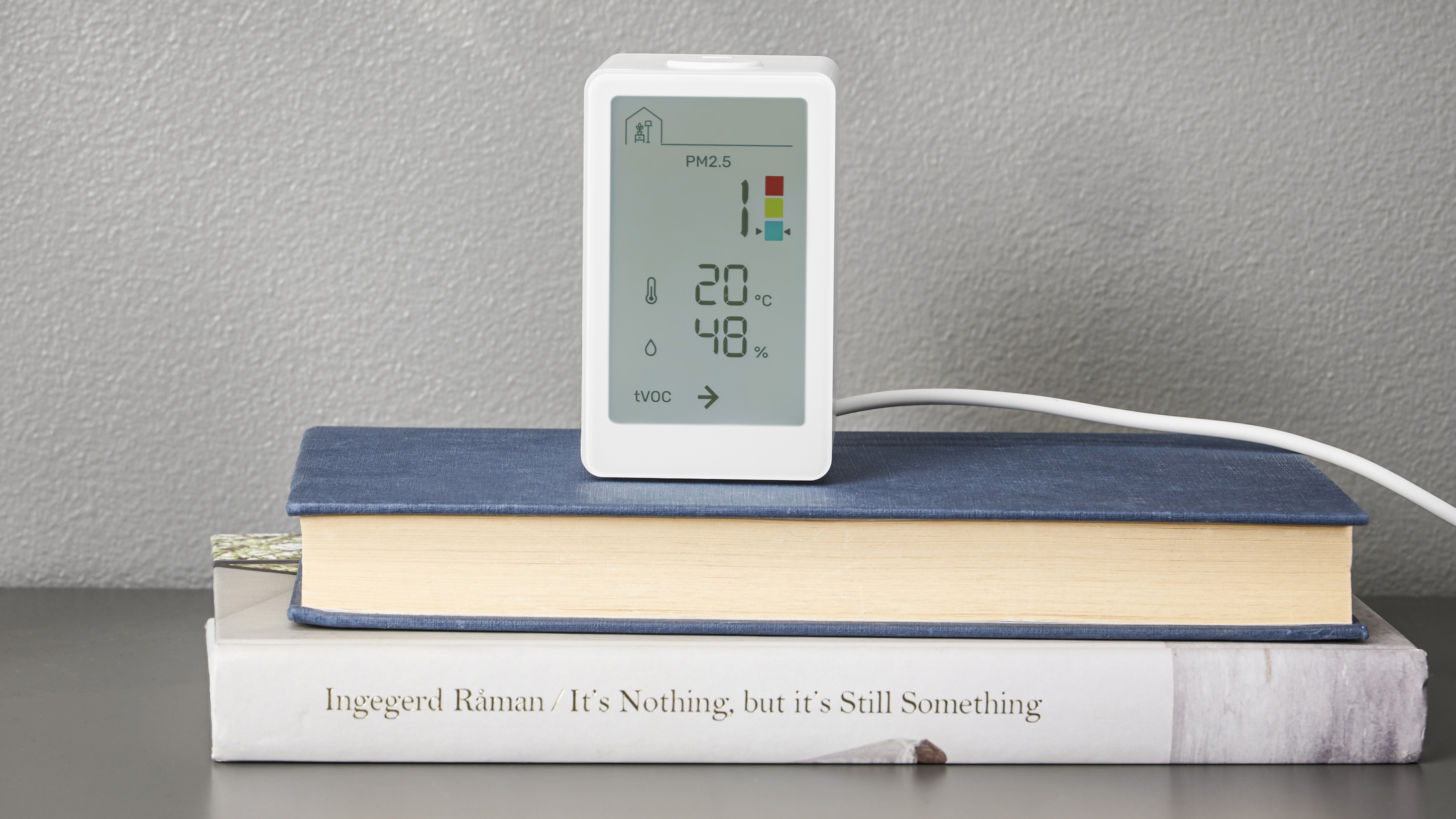 The IKEA VINDSTYRKA smart air quality monitor on a table
