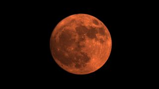 A red orb sits on a black background