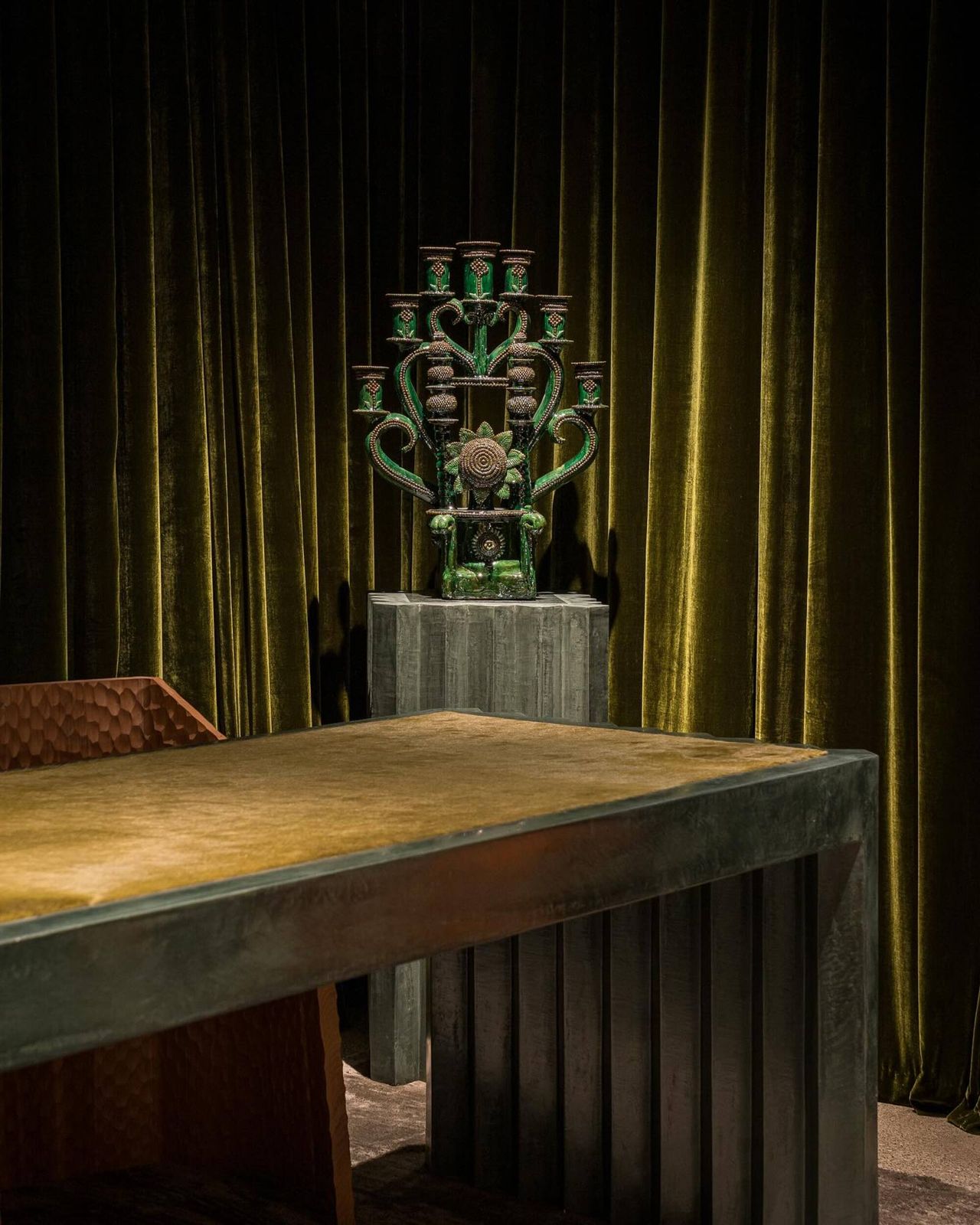 room with velvet green draped curtains and a green desk