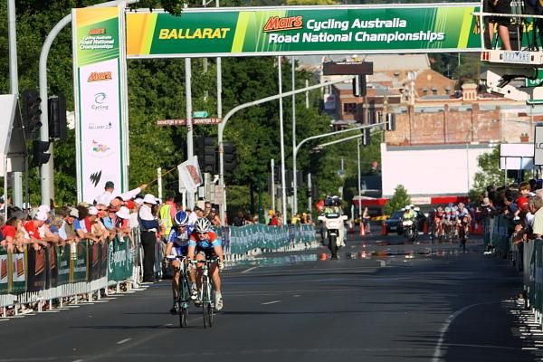 Lauren Kitchen (Jayco-AIS) and Joanne Hogan (Jayco-VIS) pass under the finish banner with two laps to go.