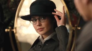 Gal Gadot admirers her new glasses in the mirror in Wonder Woman.