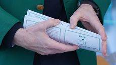 a close up of an Augusta National member holding a Masters scorecard