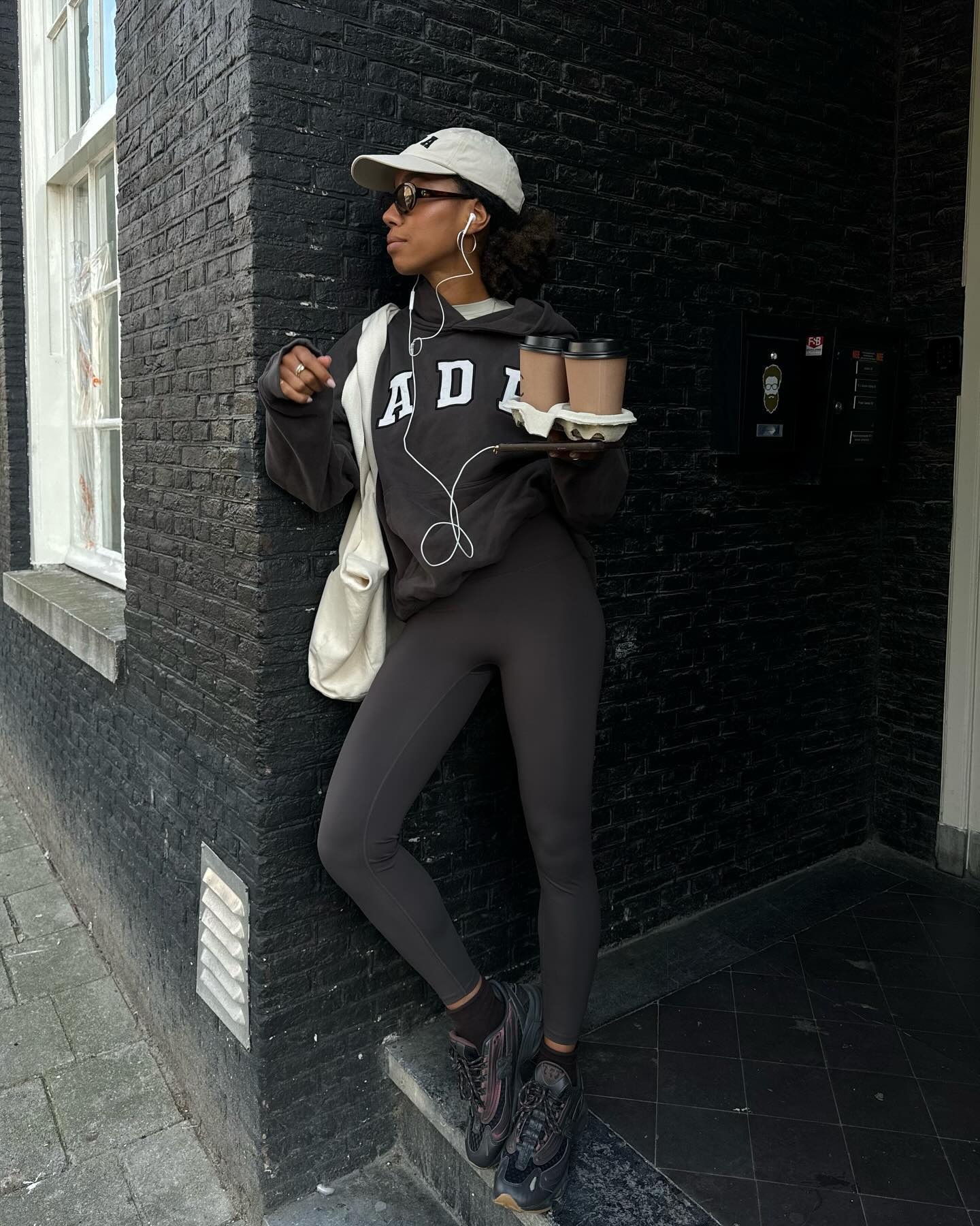 @amaka.hamelijnck wears charcoal leggings with a charcoal hoodie, cap and sneakers.