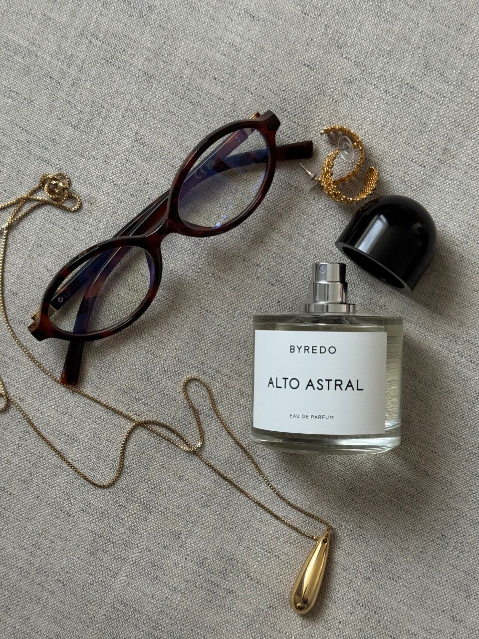 An image showing perfume, jewellery and glasses