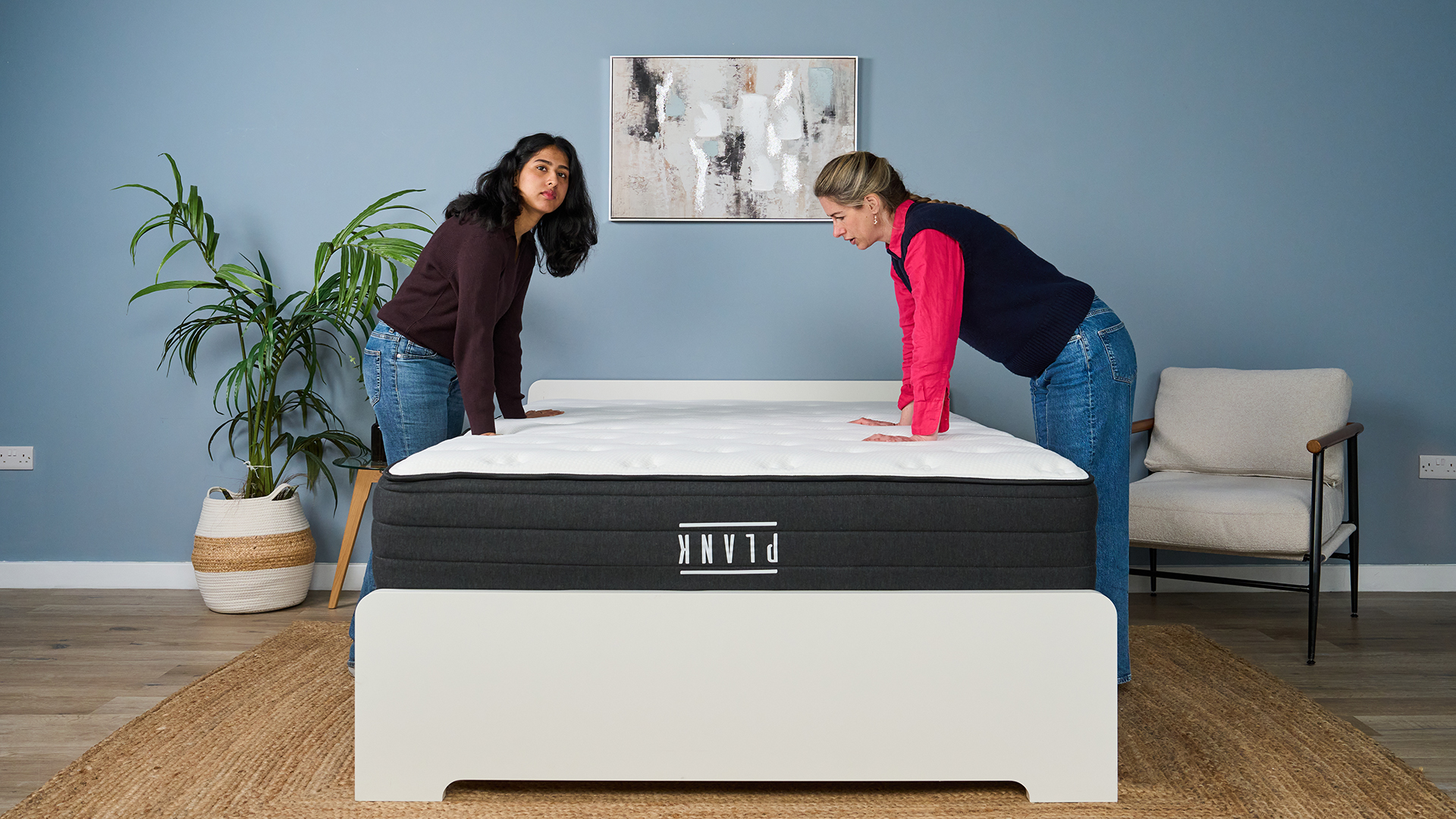 Mattress testers Becky George (left) and Nicola Appleton (right) test out the firmness of the Plank Firm Luxe mattress in our Sleep Studio