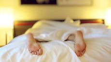 The feet of a person sleeping in a bed