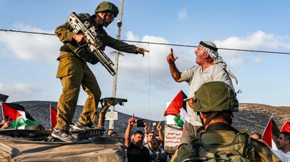 A Palestinian protester argues with an Israeli soldier in the West Bank